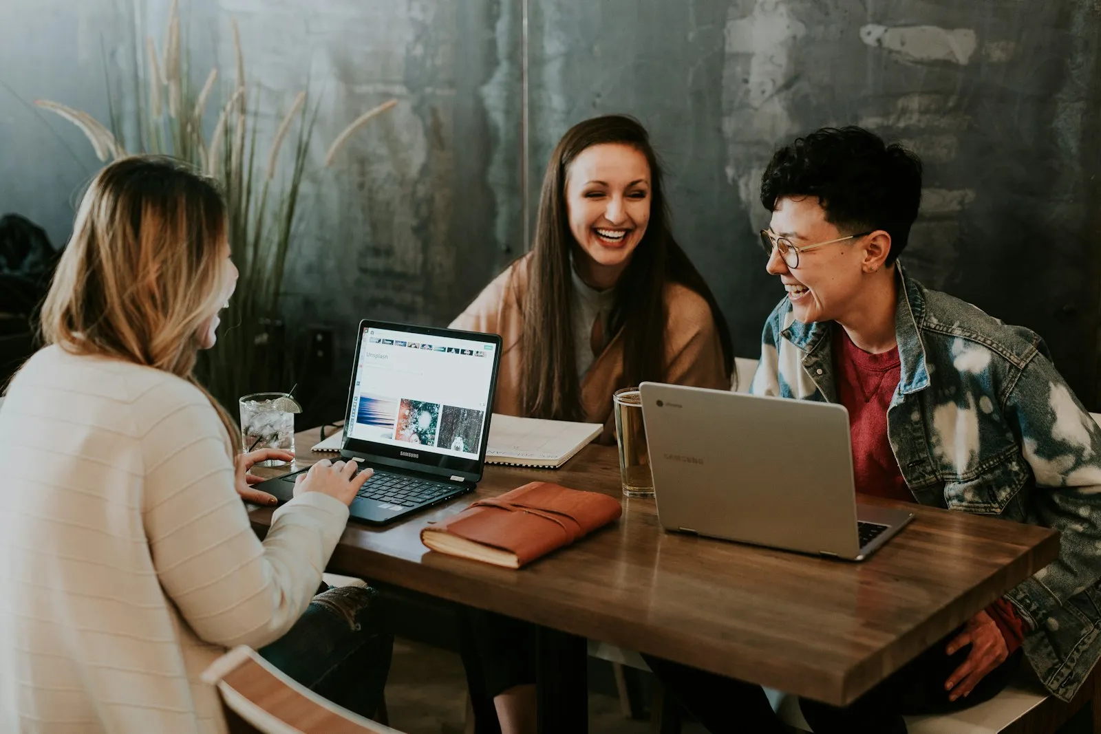 Colleagues laughing together over laptops