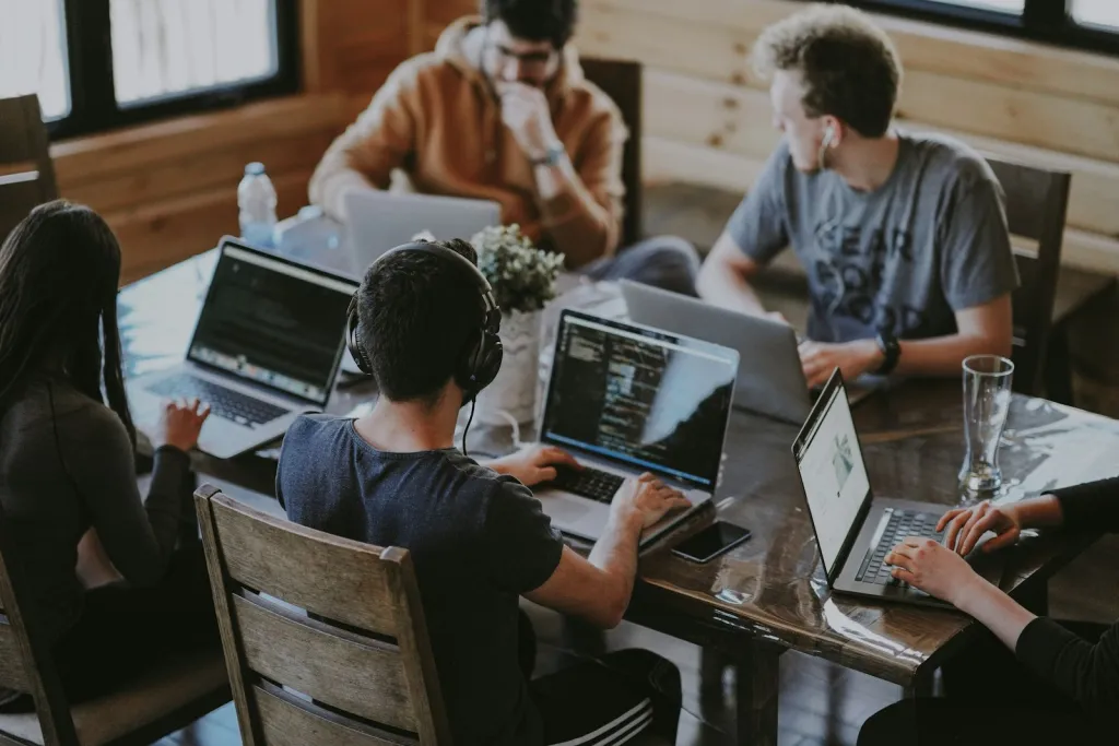 Engineers working together on laptops around a table