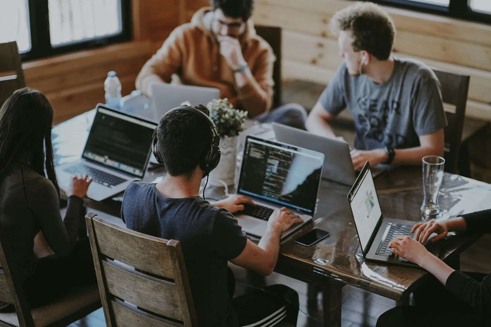 Engineers working together on laptops around a table