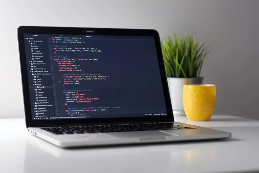 Laptop showing source code on a white desk
