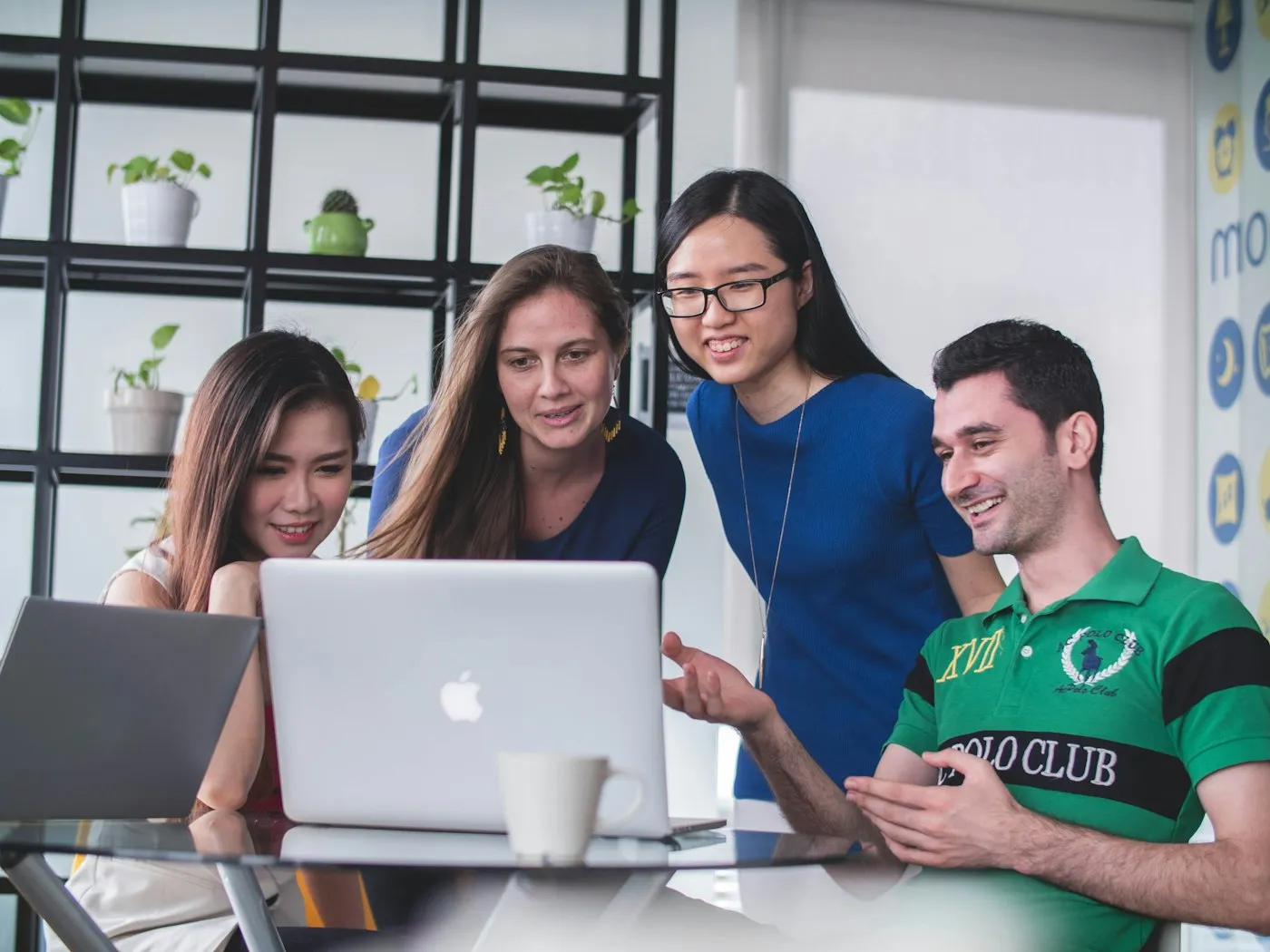 Multilingual team collaborating around a laptop