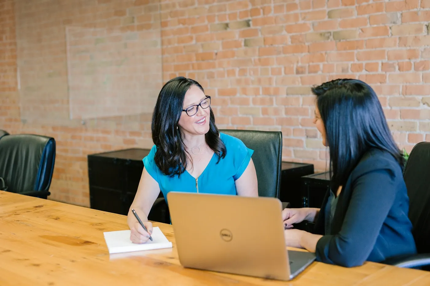 Two colleagues reviewing a client proposal together on a laptop
